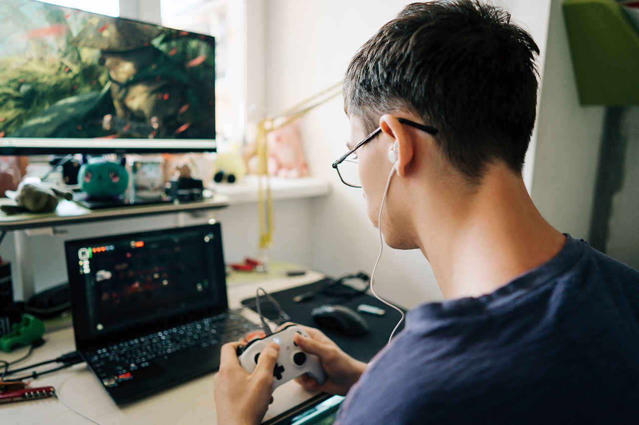 Teenager zockt am Gaming-Laptop