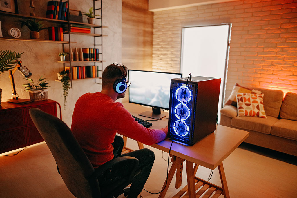 Mann sitzt am Gaming-PC und spielt Video-Spiele