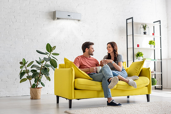 Paar sitzt auf dem Sofa und genießt die Klimaanlage