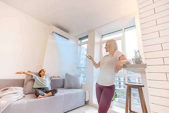 Mutter und Tochter im Wohnzimmer testen die Klimaanlage